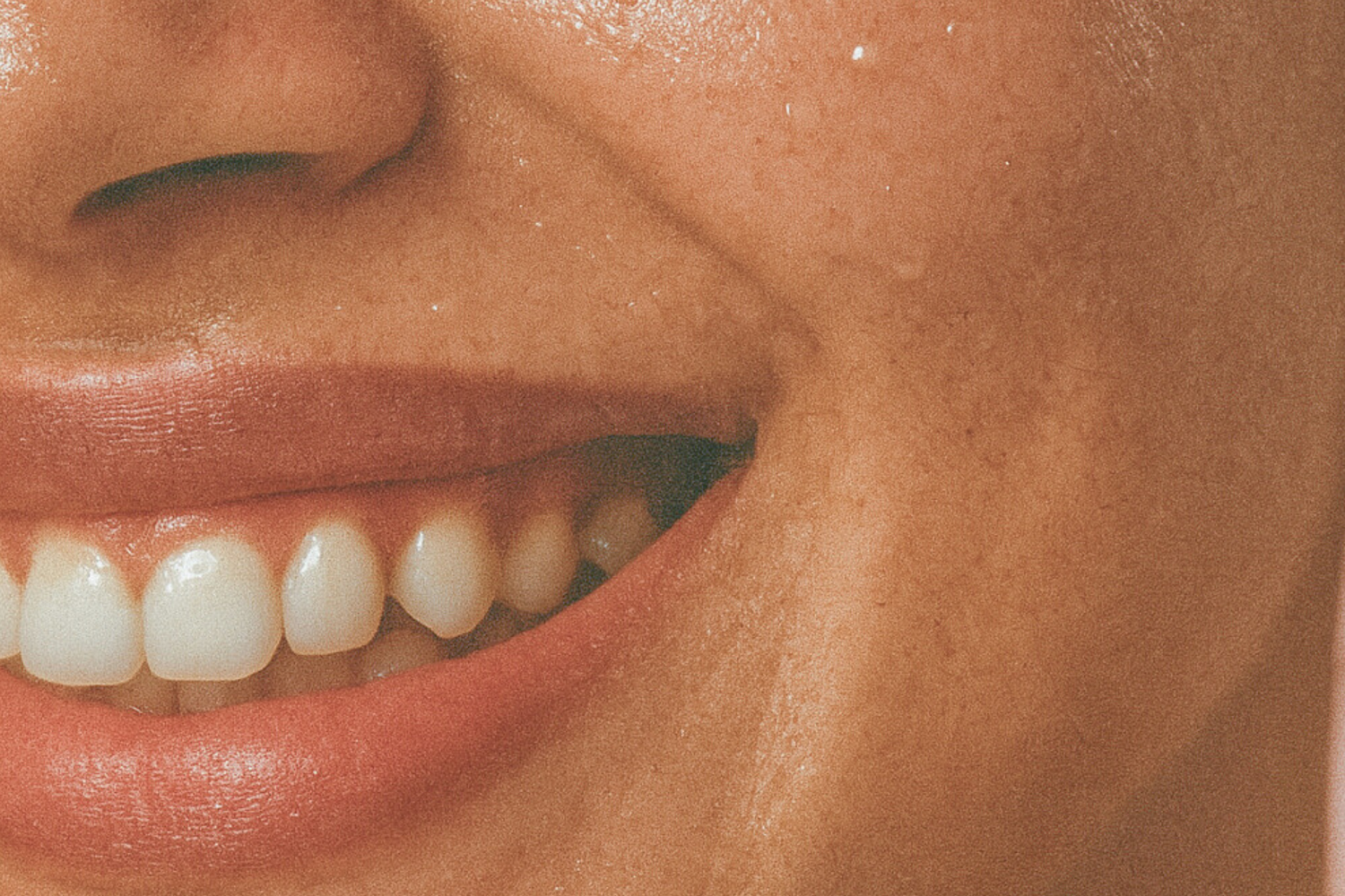 Une femme à la peau mate sourit.
