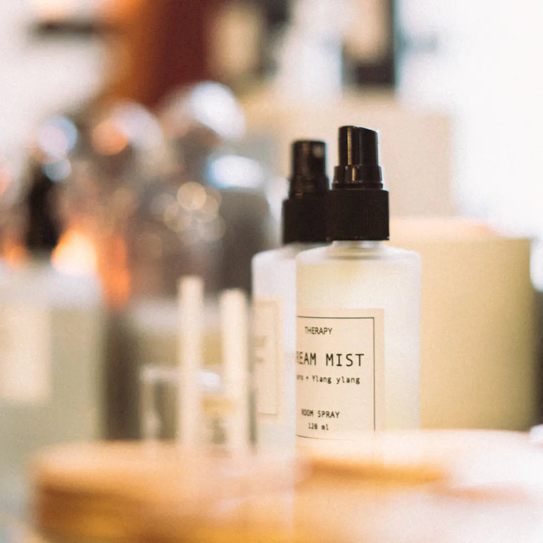 2 flacons de produits cosmétiques en spray sur une table.