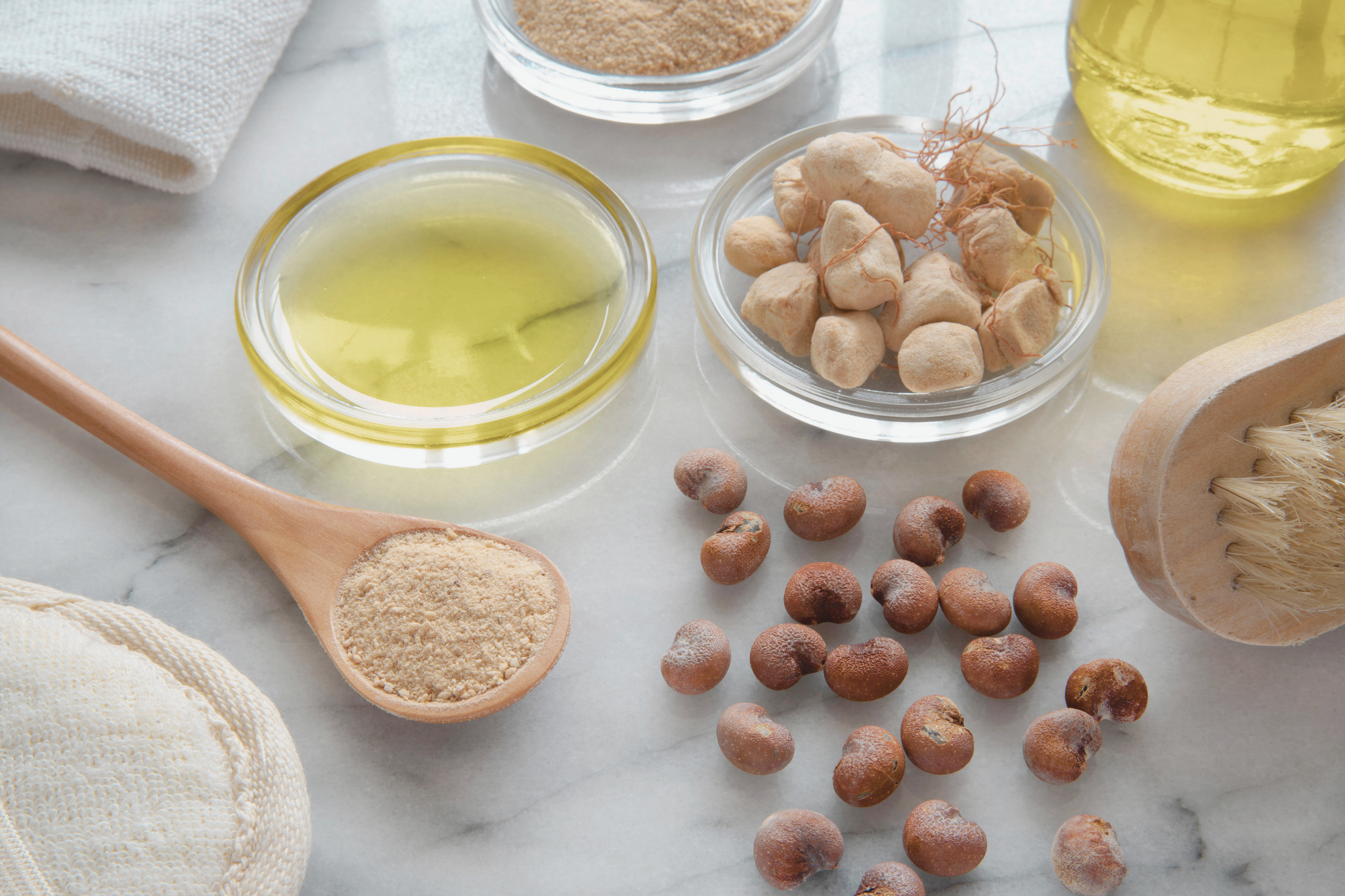 Baobab en grain, en huile et en poudre posés sur une table en marbre.